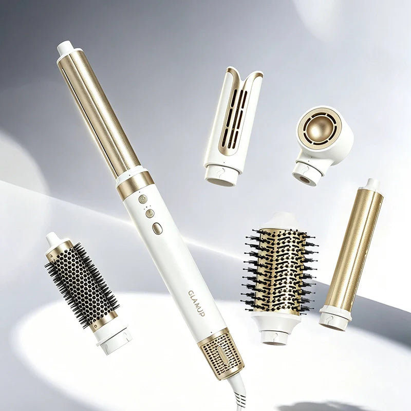 The white and gold premium GLAMUP multi-styler system laid out with its interchangeable engineering styling attachments, including an air curling barrel, volumizing brush, and dryer.