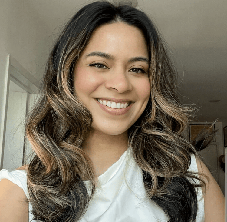 Woman with wavy hair smiling indoors