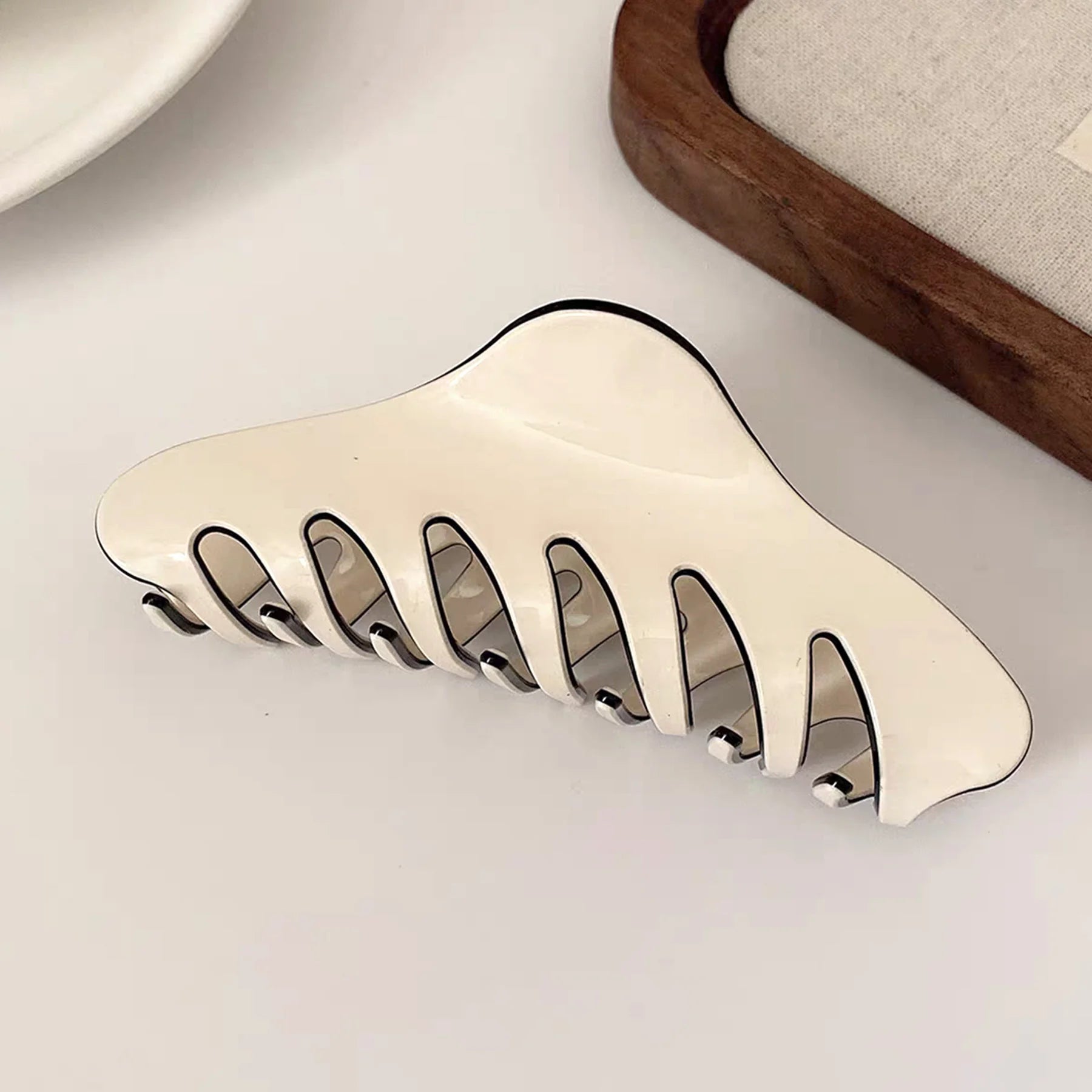 Close-up studio view of the white Glamup claw clip, engineered to provide a reliable all day hold for thick hair types.