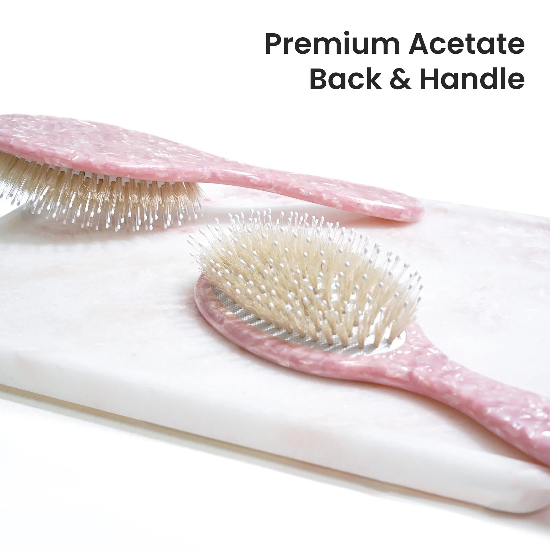 Detailed view of the Glamup cushion brush head with pure white boar bristles and massage nylon pins, designed to distribute natural oils and boost shine.