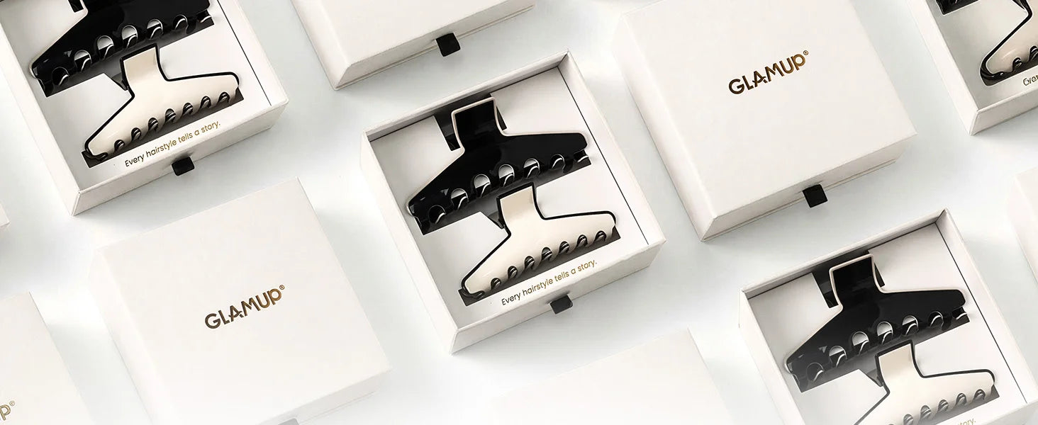 Top-down studio view of GLAMUP The Kendall large acetate claw clip packaged neatly in luxury branded gift boxes for gifting.