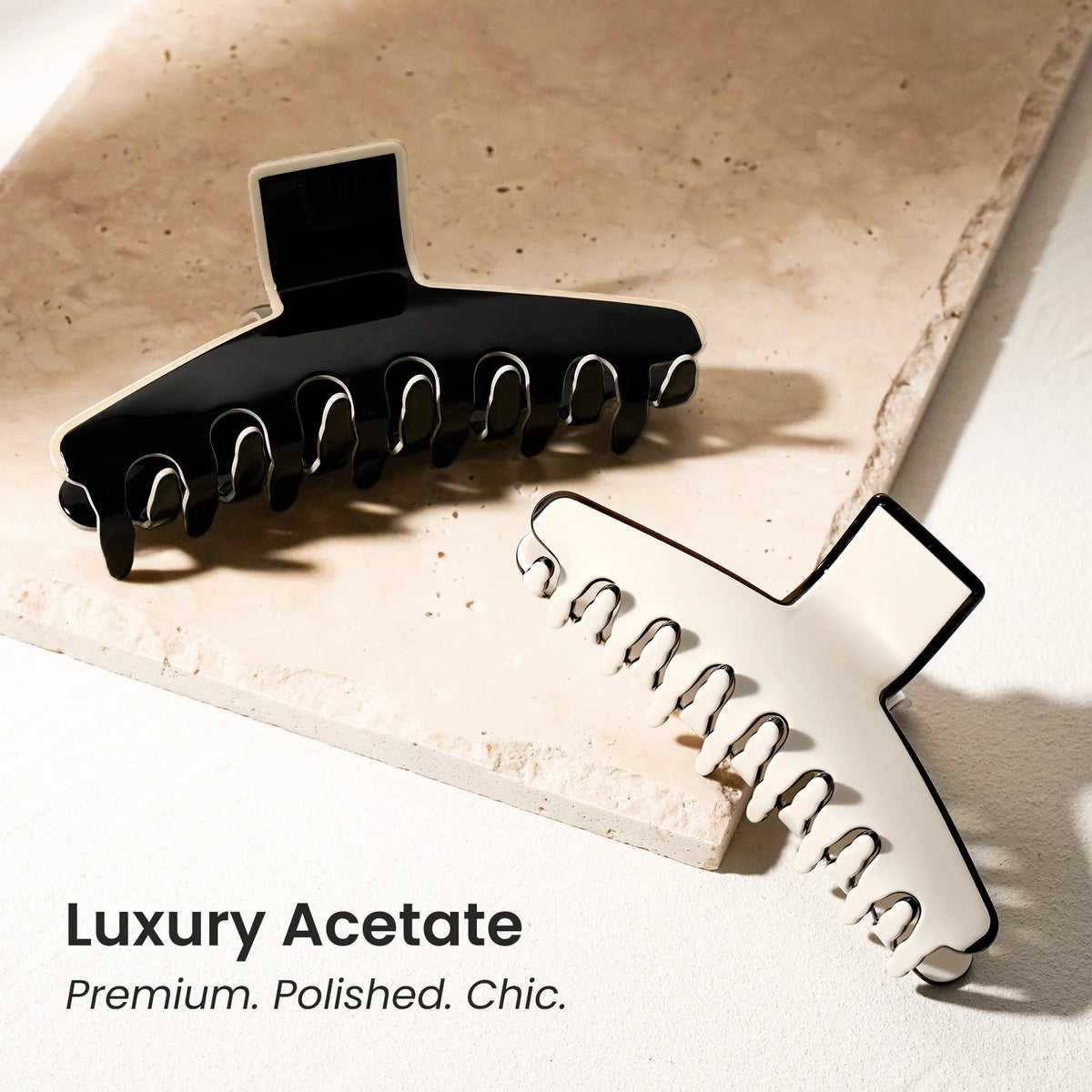 The Kendall large acetate claw clip resting on a textured stone base, highlighting the premium polished material and chic aesthetic.