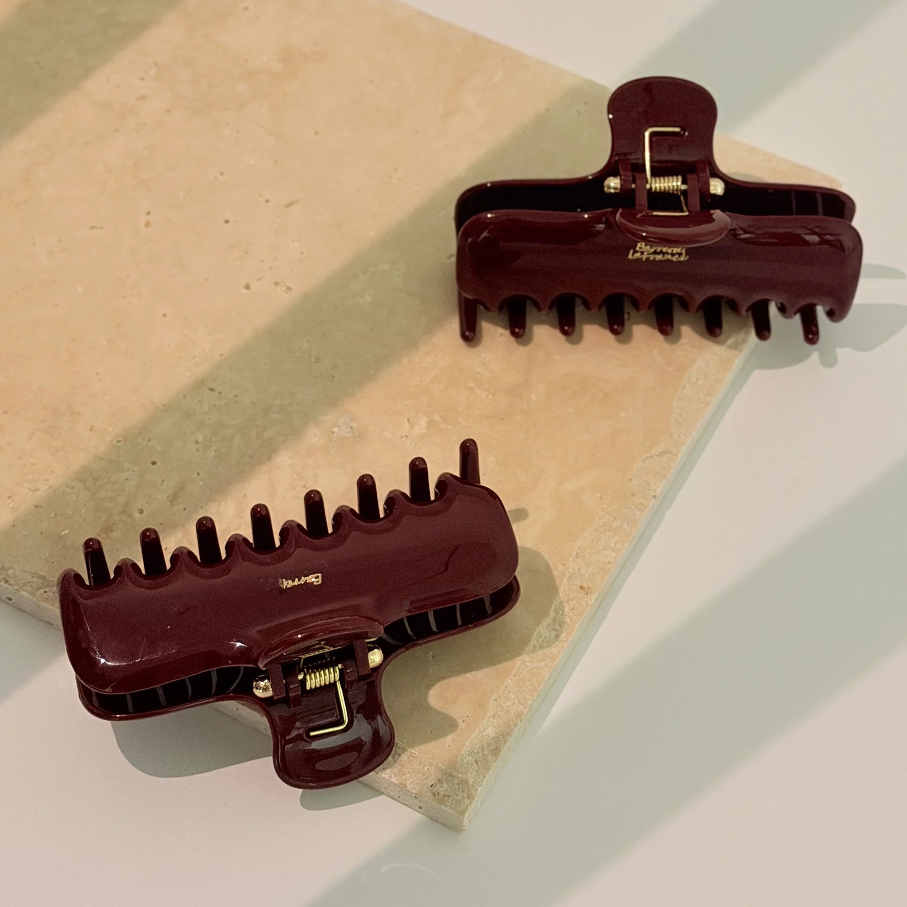 Close-up of dark Glamup The Taylor claw clip variants featuring double-row teeth designed to provide all-day hold for thick hair types.