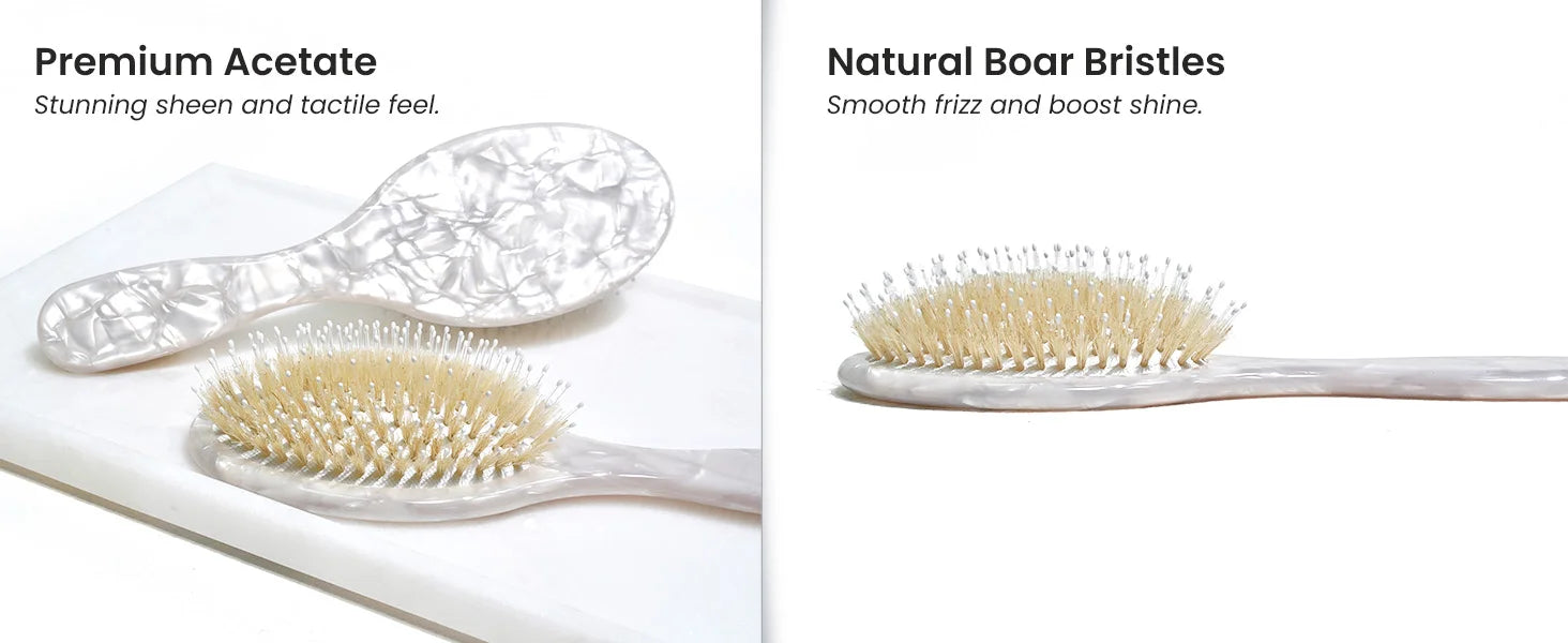 Close-up view of Glamup luxury cushion hair brush, highlighting the hand-polished white marble acetate handle and the mixed natural boar bristles with nylon pins. Designed for gentle detangling and boosting hair shine