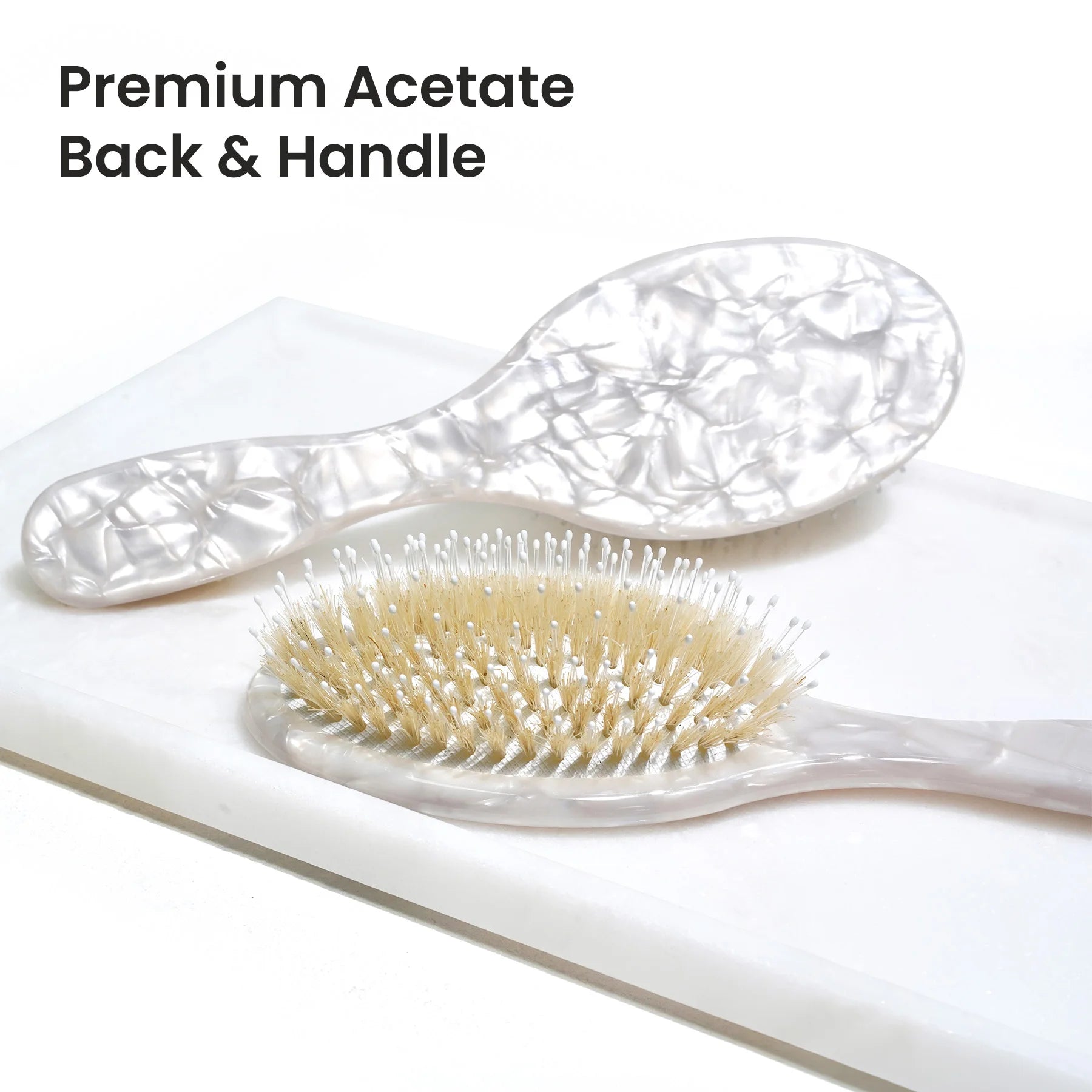 Close-up of the hand-polished, high-gloss cellulose acetate handle in white marble pattern, showcasing the luxury, durable, and non-plastic material quality of the Glamup brush.